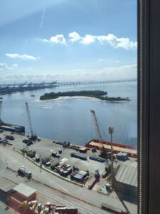 Vista da janela do escritório da Bradesco Seguros no Porto Maravilha, Rio de Janeiro, mostrando a Baía de Guanabara e a Ponte Rio-Niterói ao fundo.